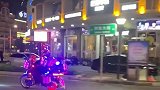 一男子骑着摩托上路，身上车上挂着各种霓虹灯盒子，里面可是骨灰