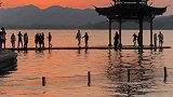 路人无意中拍下男女夕阳下湖边跳舞