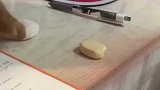 调皮猫猫想把主人的橡皮推到桌下