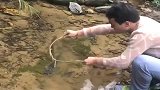 大哥拿着树根就能把大鱼套上岸，真厉害！