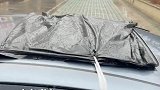 车主忘关天窗陌生人帮忙盖上塑料袋挡雨，还特意用绳子固定好