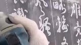 大叔用电磨机在石板上一次成型刻字