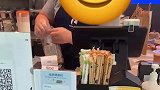 某咖啡店店员将面包，撕开后放入自家的包装袋内