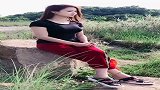 深色短袖美女坐在石头上摆拍