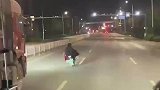 男子骑行电动车，故意挡在大货车前
