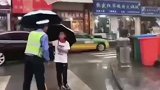 交警雨中执勤，小朋友坚持送伞