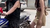 摩托车太高妻子坐不上去，老公直接蹲下背妻子上车，太暖了