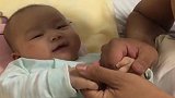 小宝宝拽着爸爸的手，还冲着爸爸傻笑，小表情萌翻了！