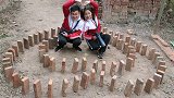 妈妈进城去了，哥哥陪傻妞在家门口玩起了摆砖游戏，有个哥哥真好