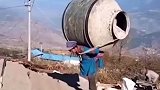 母亲为给儿子盖新房，独自扛起300斤重的搅拌机在山路负重前行