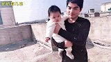 5个月的小宝宝无忧无虑，爸爸负责抱着，妈妈负责逗她，一家三口