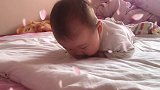 小宝宝躺在床上练习抬头，接下来的表情好可爱，简直要萌翻了！