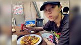 窦靖童坐垃圾桶旁吃路边摊手握勺子表情显呆萌