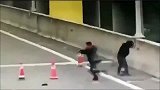 高架桥上一熊孩子只因为好玩，在马路中央摆路障