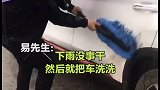 陕西一男子大雨中打伞洗车 网友：省洗车费了！