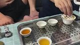 茶水溢出了杯子，好友敲击桌子示意