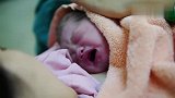 还在产床上的妈妈第一时间安抚刚出生的宝宝,母爱的伟大令人感动