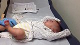 宝宝正好奇的东张西望开心的躺着，不料被医生打了一针后，变脸了