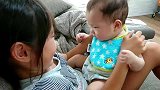 姐姐不停挤弄宝宝小胖脸，把娃气的哇哇大叫要咬人，大人都笑疯了