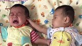 哥哥已经在哭了，弟弟不仅摸哥哥的脸还拽耳朵，真让人生气啊！