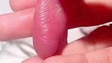 女子轻轻抚摸着早产婴儿的脚掌