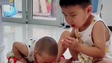 等不及妈妈拿工具，俩萌娃率先开吃
