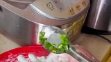 女子在手上包韭菜，随后放到油锅里煎