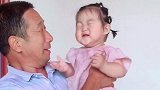 外公把宝宝抱在怀中，小宝宝一脸嫌弃的表情实在太可爱了