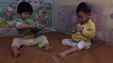 两个小宝宝都想要球，结果都把球塞进自己衣服里面