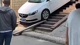 轿车下楼慢悠悠，路人见状拿来木板垫着