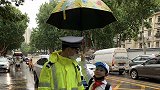 交警雨中执勤 小学生跑过来踮脚为他撑伞 两人相视而笑超有爱！