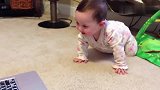 充满好奇的小宝宝对着电脑前慢慢的爬
