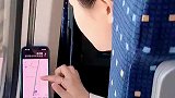 女子乘坐高铁，用手机开导航望向窗外