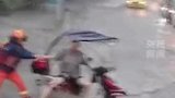 重庆暴雨，一名摩托车骑手被困在激流中，消防员发现后努力将其拉回至岸边，成功救援被困男子