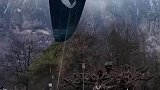 男子穿戴着滑翔伞，在空地上起飞