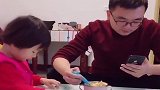 爸爸边玩手机边喂女儿吃饭，心不在焉，都喂到老婆嘴里了