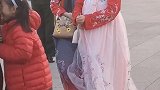 汉服小姐姐在广场上拍照，后面是身姿挺拔的军人