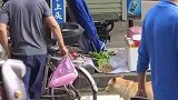大叔骑自行车出来买菜，狗狗熟练地跳上自行车后座，跟主人一起回家
