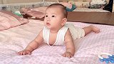 爸爸让宝宝舔下桃子，没想到宝宝吃的津津有味，还不忘用床单擦嘴