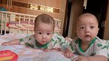 双胞胎宝宝练抬头，哥哥睁大眼睛看着妈妈，弟弟却快累的睡着了