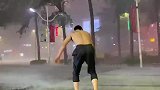 台风来袭雨势大，男子即兴雨中跳舞