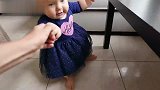 宝宝正扶着椅子站着，忽然宝妈向宝宝伸出手，太搞笑了