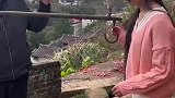 女生单手抓着铁钩，双脚悬空称重