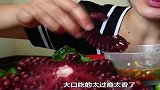 小姐姐吃黑红色的大章鱼，拿起一条腿蘸酱吃，吃相诱人