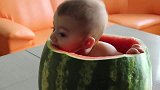 小宝宝被爸爸放进吃空的西瓜里，小娃一边玩一边吃，一脸的小惬意
