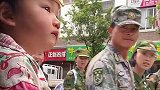 萌娃爬车窗，看身穿迷彩服的学生，路过的学生热情打招呼