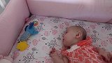 小宝宝独自在婴儿床对着玩偶咿呀学语，小模样真可爱