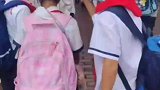男孩专心给女同学一路撑伞