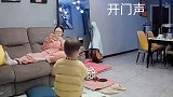老婆正在玩手机，听到老公开门声，赶紧抱起小孩