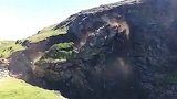 2名登山者漫步悬崖顶峰 下一秒脚边岩石崩塌